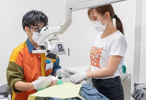 歯科医師がマイクロスコープを除きながら治療する姿